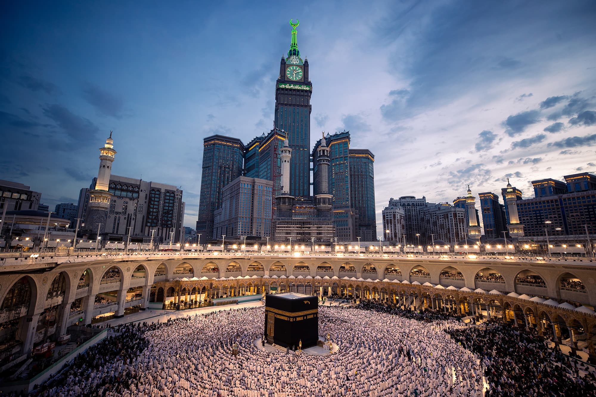 Kaaba and Clock Tower at dusk with worshippers