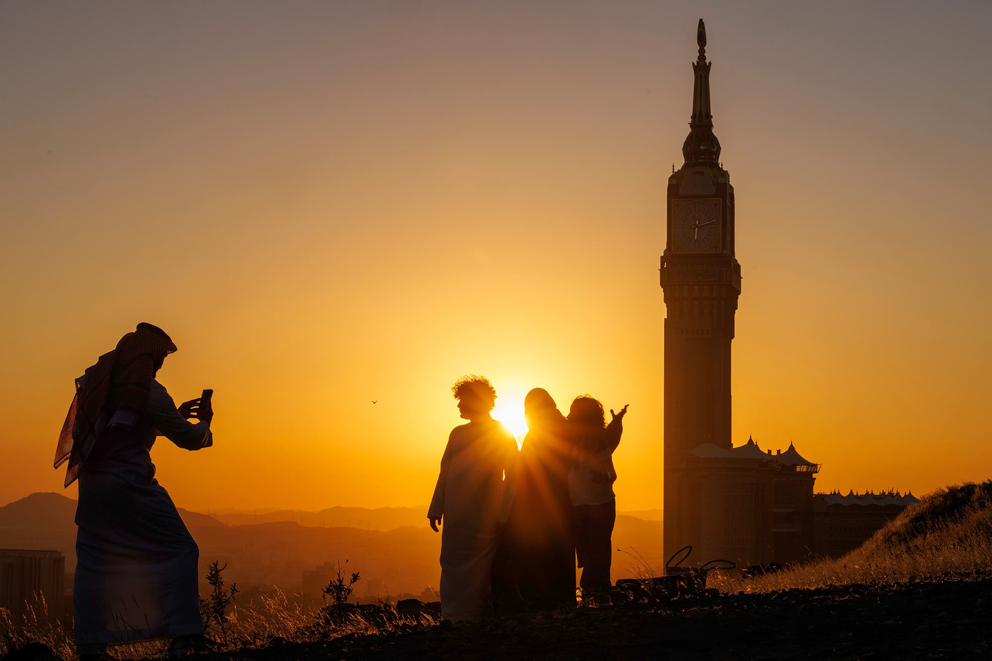 Silhouettes at sunset with Makkah Clock Tower